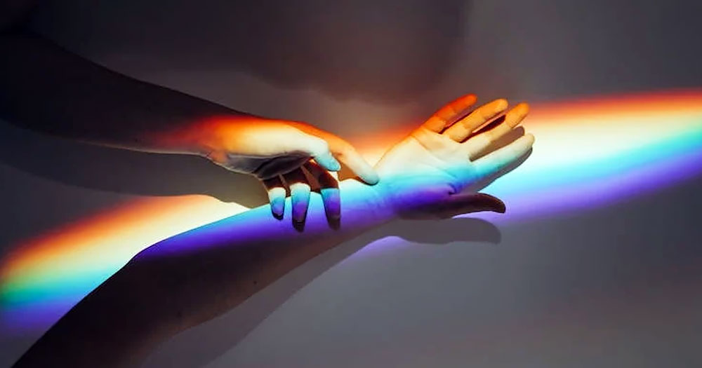 This article is about the fluidity of sexual identity. In the picture, two arms intertwining with a rainbow.