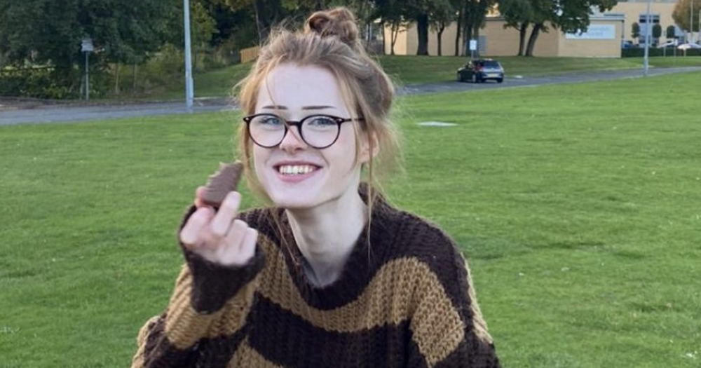 A photograph of a young teen girl called Brianna Ghey wearing glasses and a brown striped jumper.