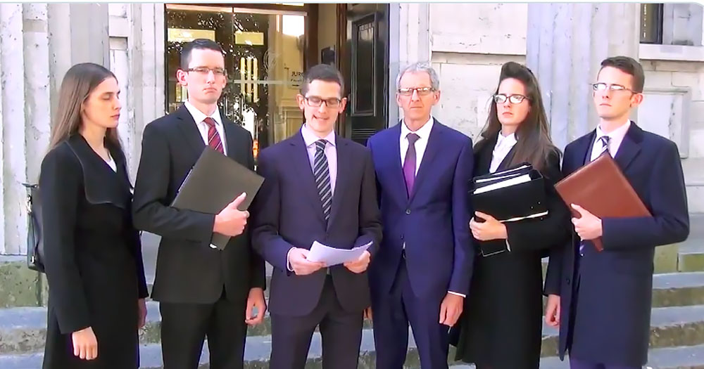The Burke family, who paid for attack ads against politician who support LGBTQ+ rights, standing in front of a building and speaking to reporters.