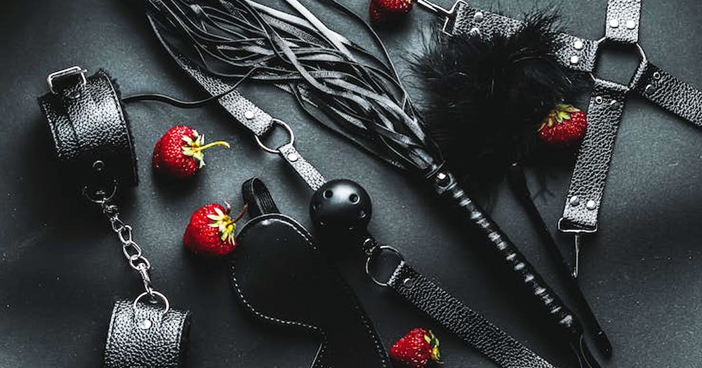This article is about a lesbian couple explaining their BDSM dynamics. In the photo, a series of object typically related to BDSM play: handcuffs, whips, mouthgags, blindfolds.