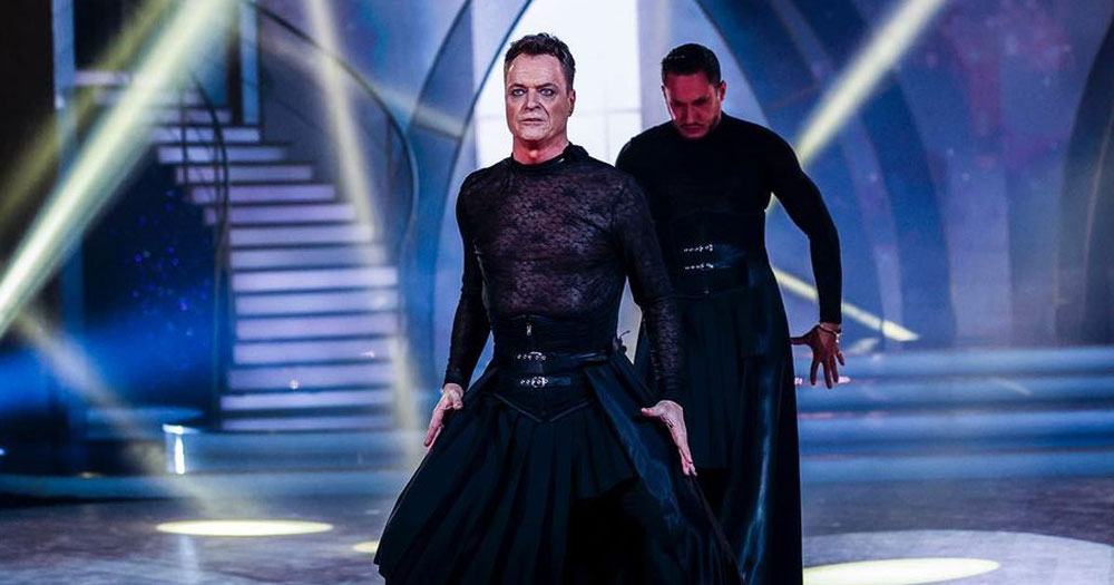 Rory O'Neill performing on Dancing with the Stars against HIV stigma with his pro partner Denys Samson. They are wearing black clothes and dancing in blue lights.