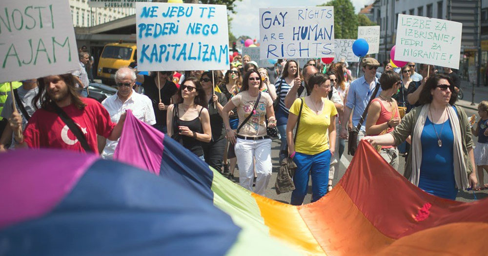 Pride Parade in Slovenia, where marriage equality has officially been established, with people carrying banners and a big Pride flag.