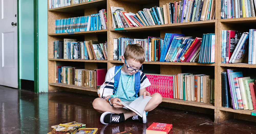 Child sits in front of bookshelf reading a book, Dublin libraries will not be removing trans books from the children’s section following complaints from a women’s group.