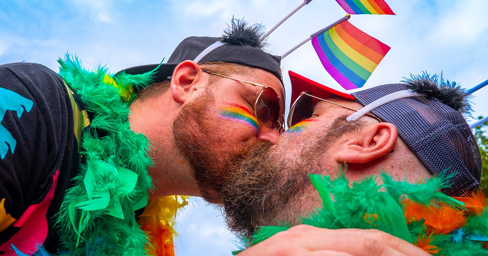 Two Dublin Bears kissing with Pride flags and outfits.