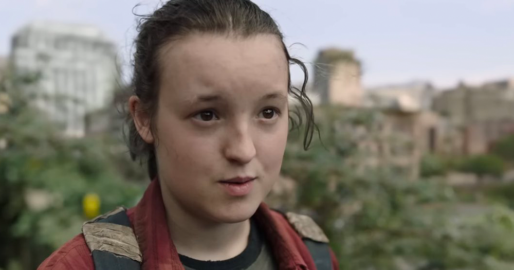 Bella Ramsey faces camera with city in background on the set of The Last of Us where they have received support for their role.