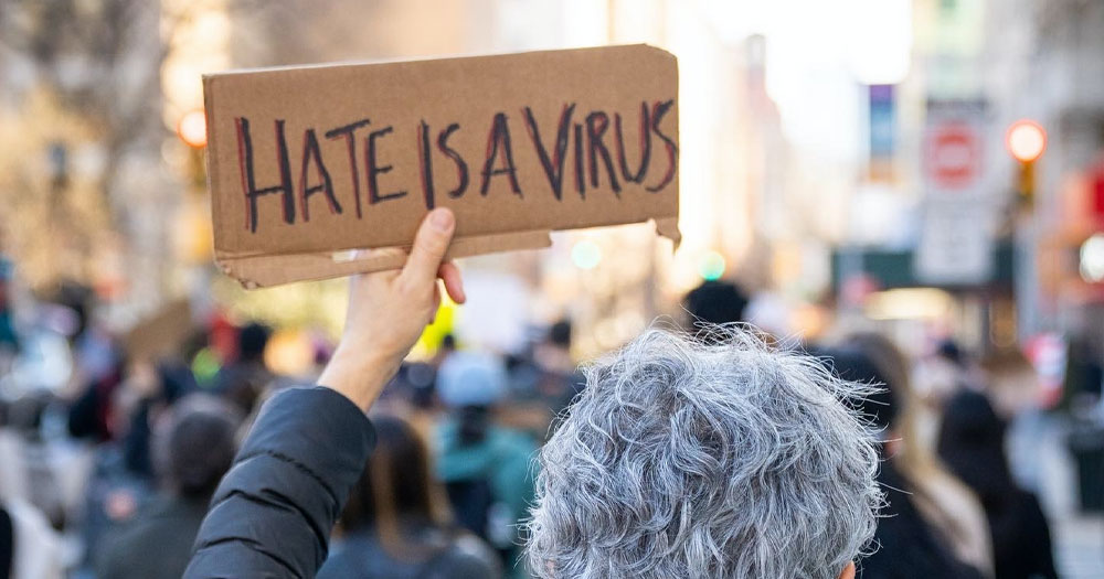 This article is about hate crimes in Ireland. In the photo, a person holding a sign that reads 