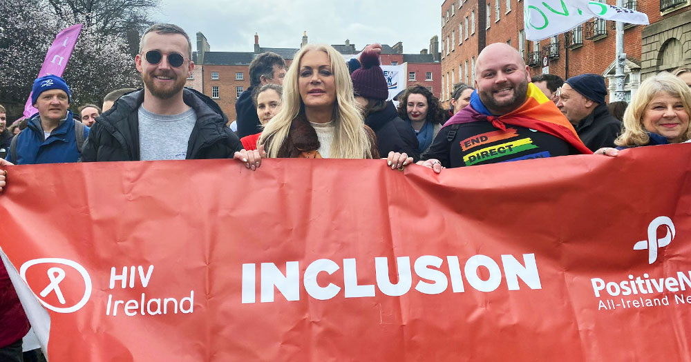 Activist of HIV Ireland, which will receive a donation from the Sunday Times, marching in a protest carrying a banner with their logo and the word 