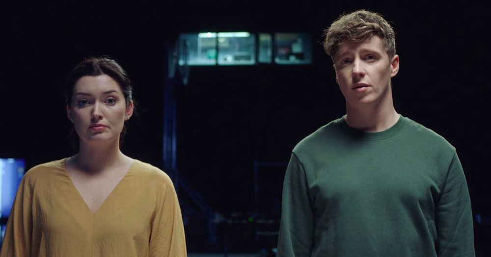 Screenshot from the movie How to Tell a Secret, which was nominated for two IFTA awards, showing two people looking at the camera with a serious expression.