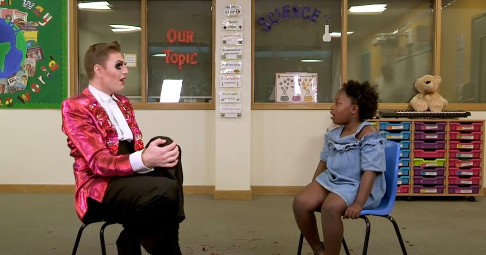 An image of Reuben Kaye speaking with a child about drag.