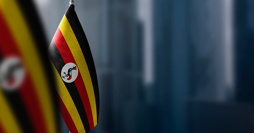 Uganda flag against a grey background.