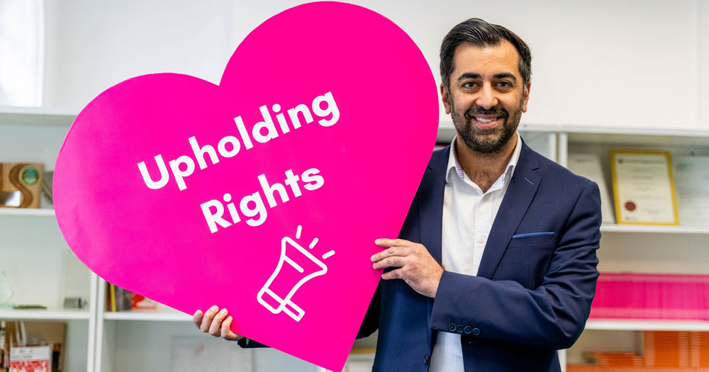 Humza Yousaf, the new leader of the Scottish National Party, holding a big hearth in bright pink with the message "Upholding rights".