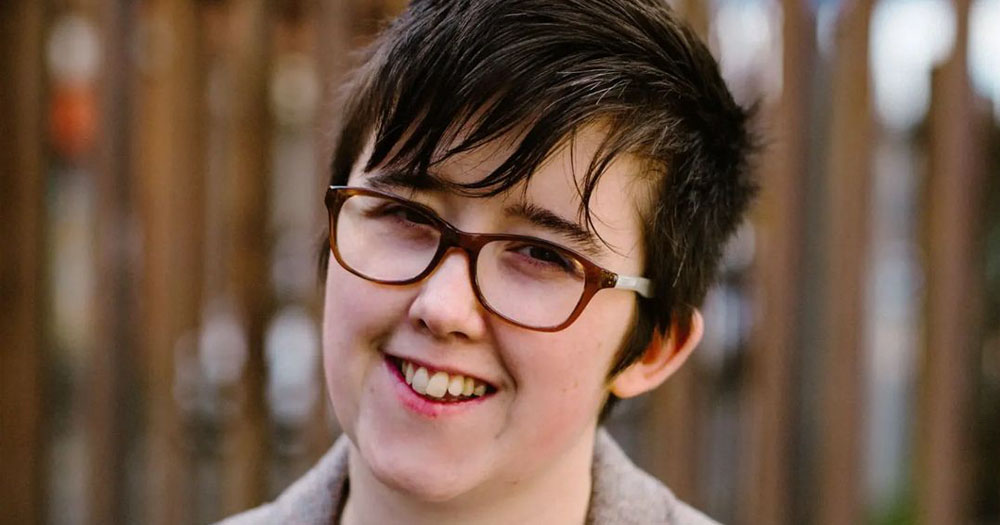 A close up headshot of Lyra McKee, who will be remembered in Good Friday commemoration. Lyra is smiling with her head tilted to the right. The photograph is taken outdoors in front of blurred railings.