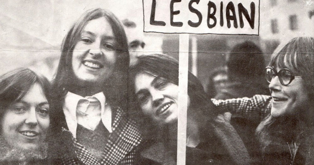 Unshrinking Violets: 50 Years of Lesbian Activism is a series of events as a part of the 2023 Bealtaine Festival. The image shows a black and white photograph of four women. One of them is holding up a placard which reads "Lesbian". The image was used on an original poster for a 1973 meeting of the Sexual Liberation Movement in Trinity College, Dublin.