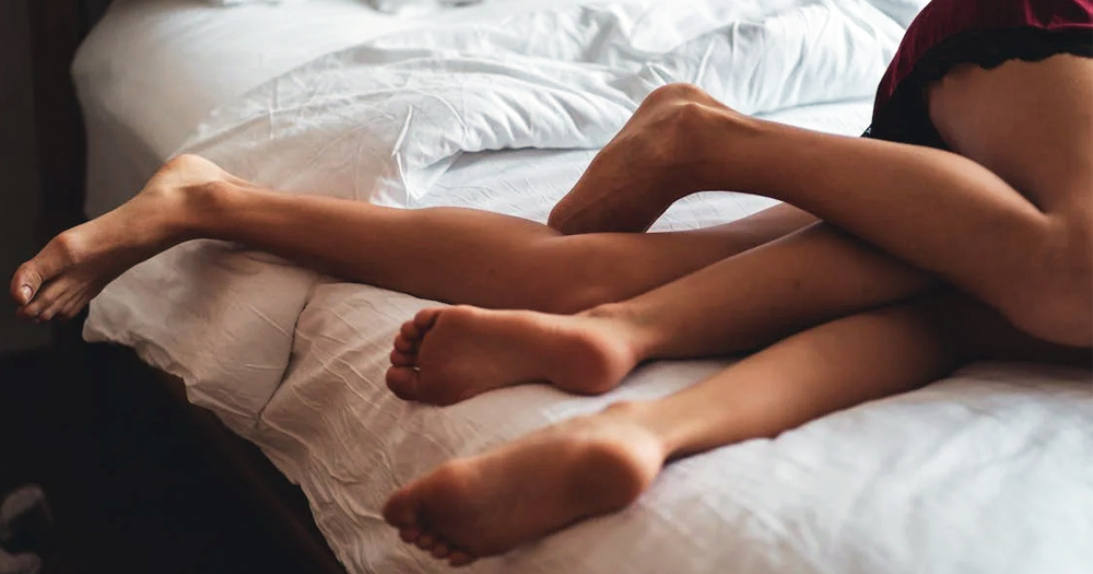 This article is about consent in sex. In the photo, the legs of two people intertwined on a bed.
