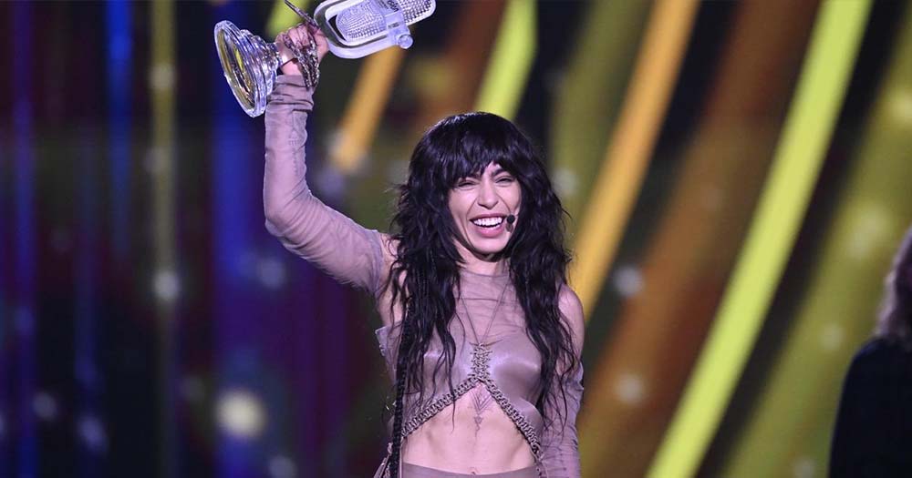 Loreen, the 2023 Eurovision winner, holds her trophy in one hand on stage.