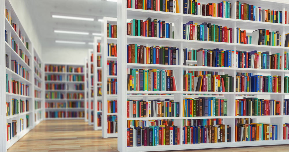 Dublin City Council has issued a motion condemning the demonstration at Swords Library and threats to staff. The image shows a library with a series of white bookshelves filled with colourful books.