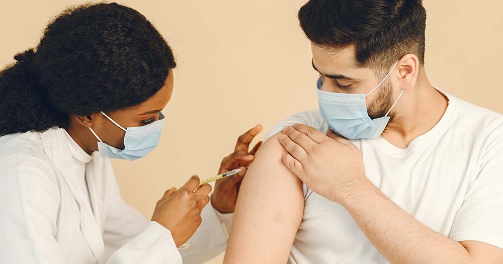woman administrating jab into a person's arm representing mpox vaccine