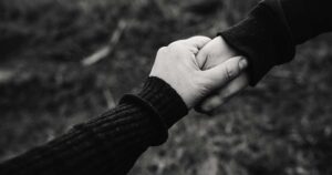 Black and white image of two holding hands symbolising a platonic partnership