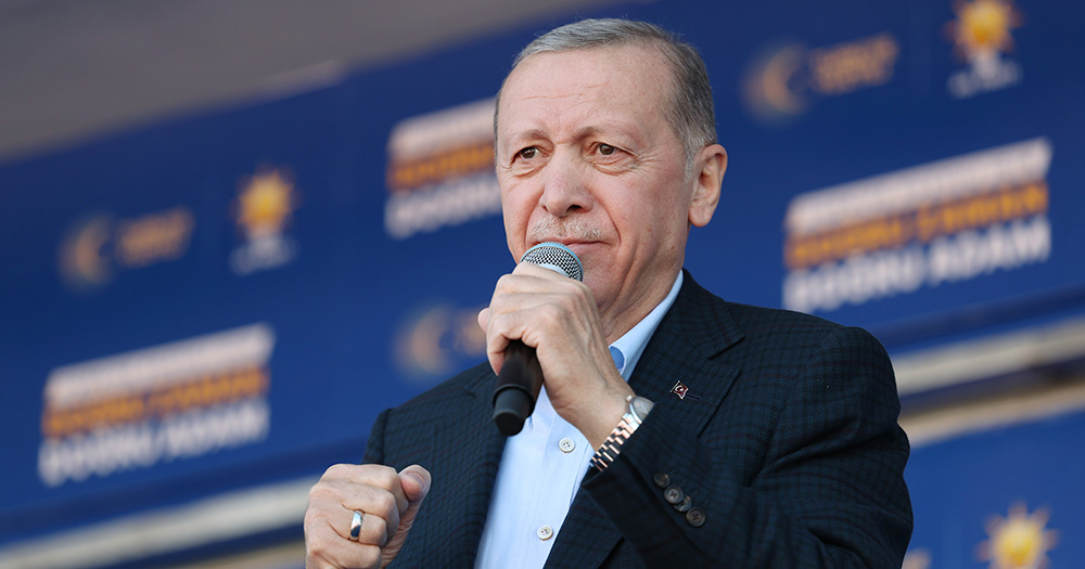 Turkey President Recep Tayyip Erdoğan holding a microphone.