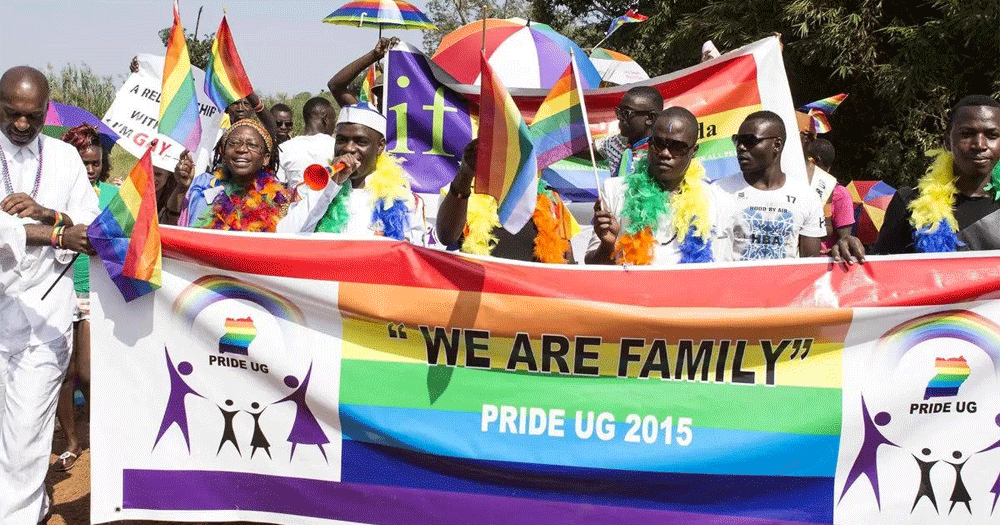 This article is about an anti-LGBTQ+ bill passed by the Ugandan parliament. In the photo, Ugandan LGBTQ+ activists marching carrying a banner that reads "we are a family" and "Pride Ug 2015", with rainbow flags.