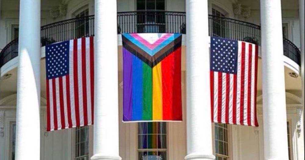 Two US flags and one progress Pride flag are displayed in front of the White House amid an increase in attacks against LGBTQ+ people in the US.