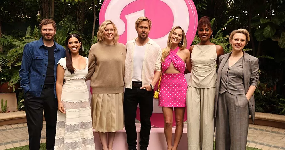 Cast of Barbie movie stands together in front of pink B as they celebrate box-office success despite far-right criticism.