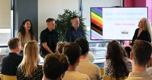 Photo taken at Certified Proud event 'Maintain the Momentum', with panel speakers speaking to a crowd.