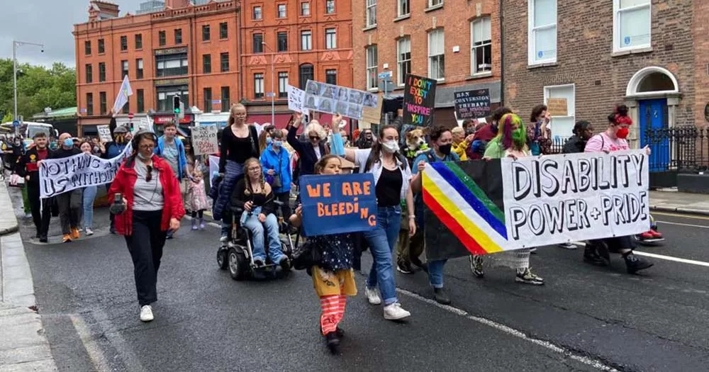 Several people carrying colourful protest banners marking the first Dublin Disability Pride.