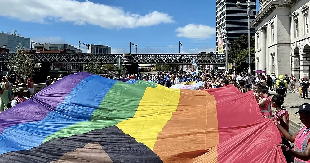 Photo from Dublin Pride 2023, which recorded a peak in spending for local economy, with a massive Pride flag transported by a group of people.
