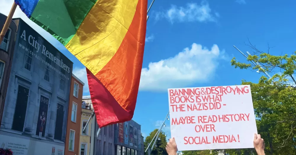 This article is about a far-right rally in front of Cork Library. In the photo, a Pride flag and a banner that reads: Banning and destroying books is what the Nazi did - maybe read history over social media!