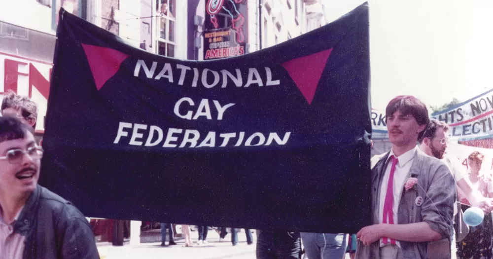 A group of people during a protest holding a sign that reads National Gay Federation