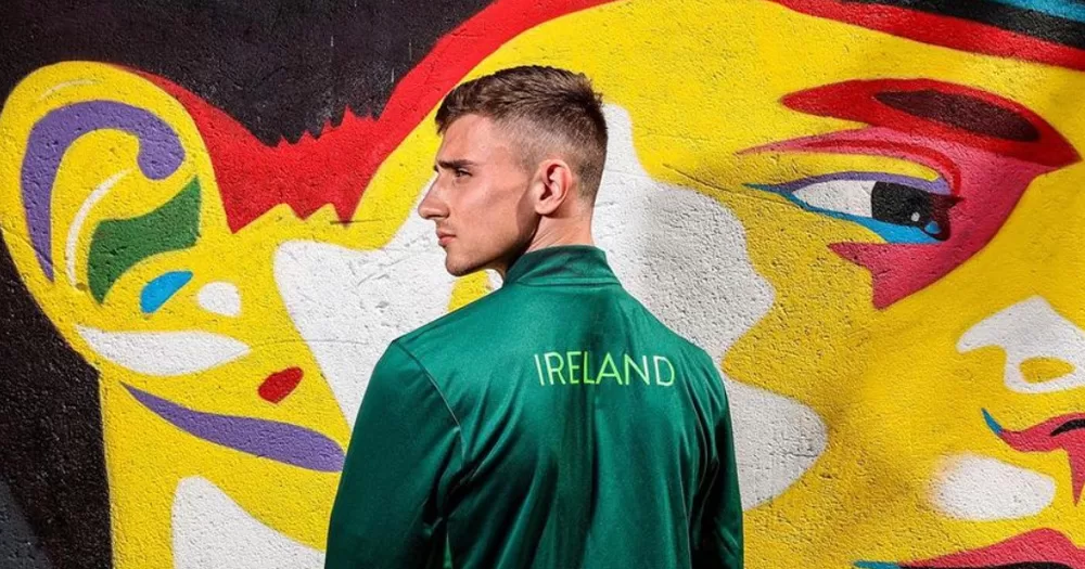 Jack Woolley posing in an Ireland jacket in front of a mural.