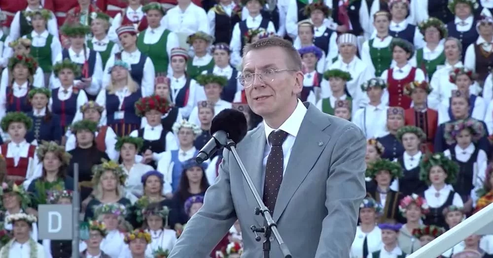 Edgars Rinkēvičs speaks into microphone in front of crowd, he was recently elected as the first openly gay President of Latvia.