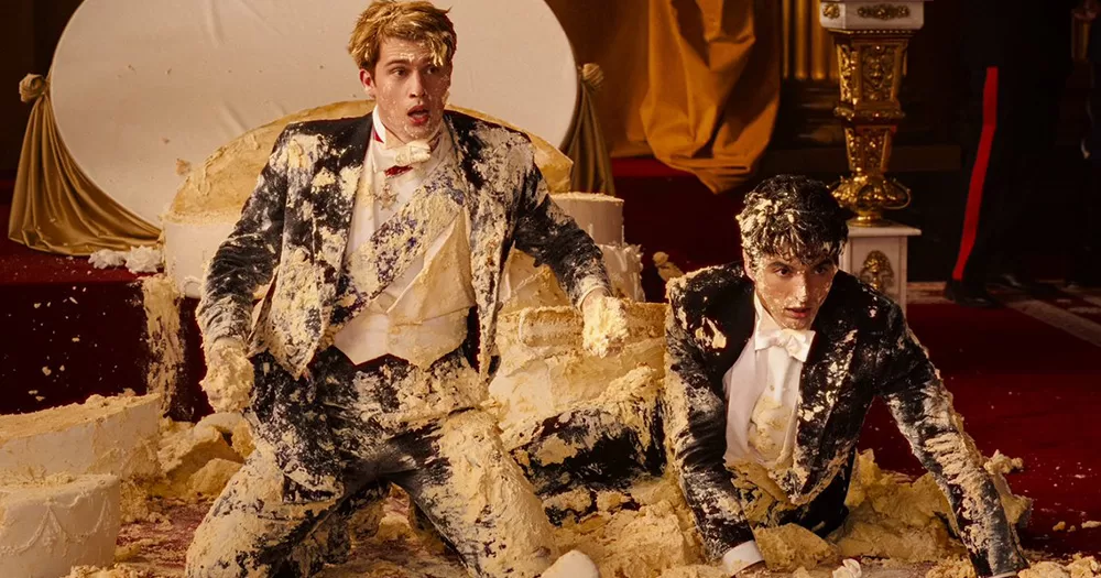Red, White & Royal Blue characters Alex and Prince Henry destroy a wedding cake.