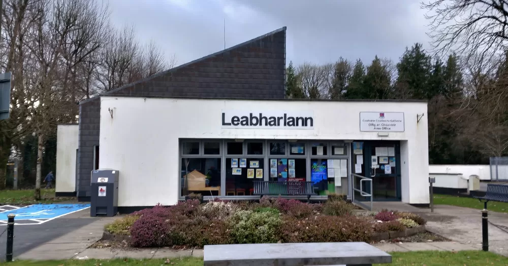 The Portumna Library in Galway. It is a white building with the word 'Leabharlann' written on it, and a bench located outside the front.