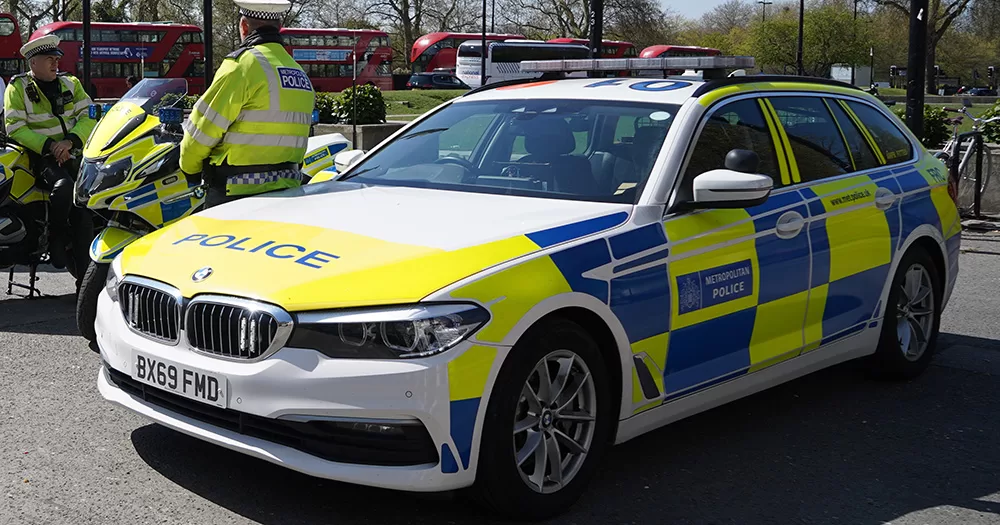 This article is about a gay couple suffering a homophobic attack in London. The image shows a Metropolitan Police car, with a blue and yellow checkered pattern.