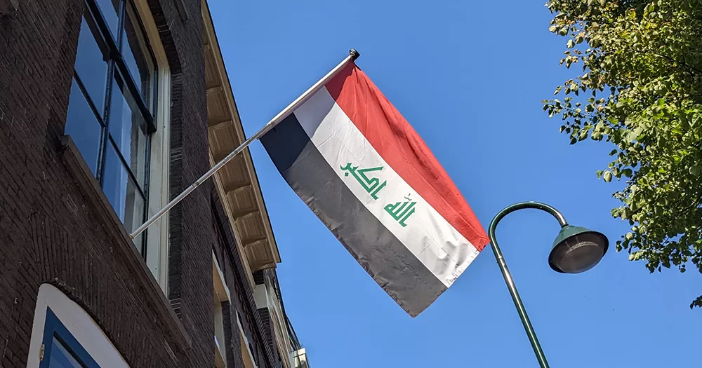 This story is about Iraq banning the use of the term 'homosexuality' in media. The picture shows an Iraqi flag (horizontal red, white and black stripes, with green writing on the white stripe) flying off the side of a building.