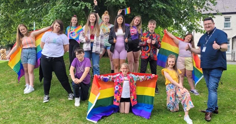 Meath Pride organiser poses with people holding Pride flags