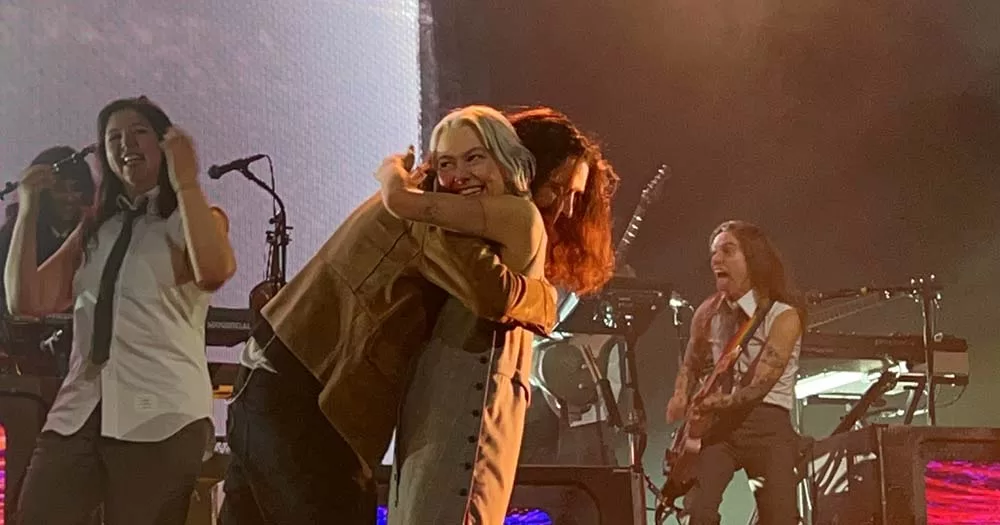 Phoebe Bridges hugs Hozier while they perform on stage
