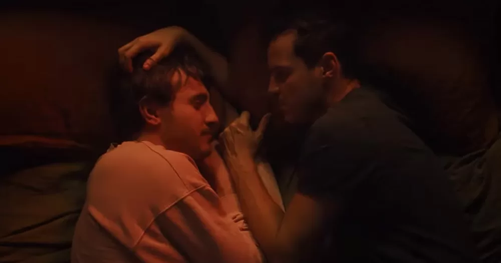 Screenshot from the trailer of All of Us Strangers, showing Paul Mescal and Andrew Scott hugging on a bed.