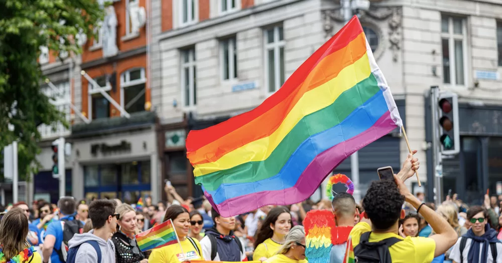 This article is about the rise of anti-LGBTQ+ rhetoric in Ireland. In the photo, people marching at Dublin Pride, with a big Pride flag in the centre of the image.