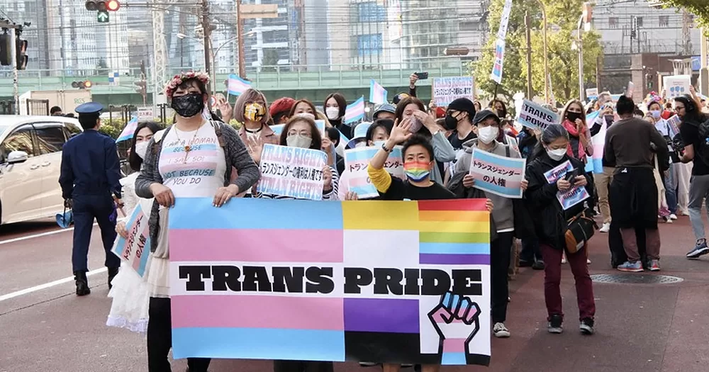 This article is about legal gender change in Japan. In the photo, a group of people marching for trans rights, with a banner that reads "trans pride".