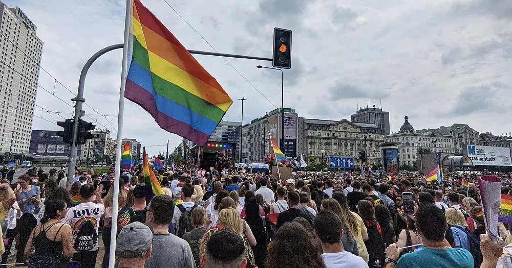 This article is about Polish elections and LGBTQ+ rights. In the photo, a Pride march in Warsaw, with people waving Pride flags.