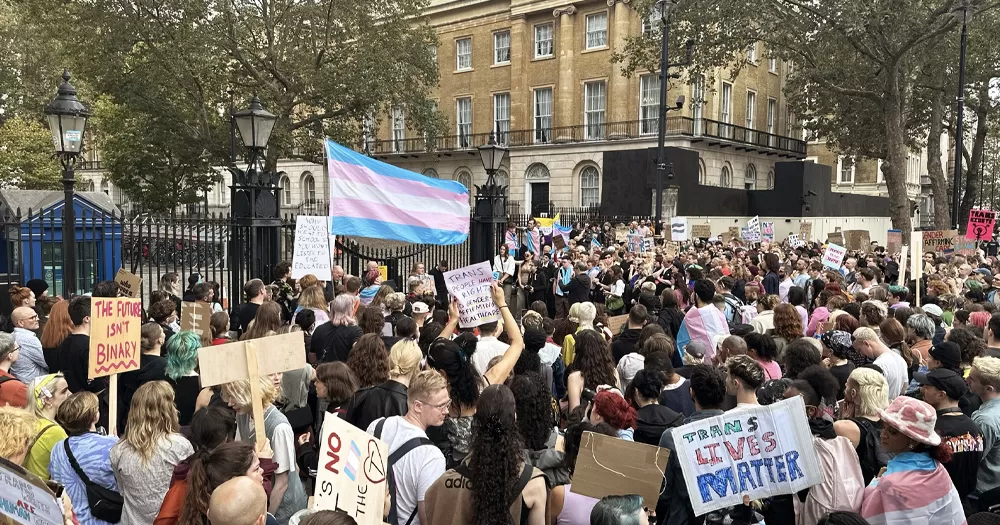Protest outside Downing Street after Rishi Sunak made anti-trans comments, with people carrying trans flags and banners with messages in support of trans rights.