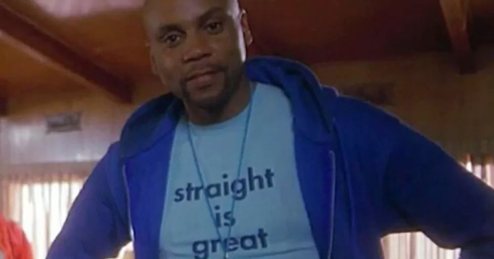 A queer costume for Halloween 2023. The image shows RuPaul in the film But I'm a Cheerleader. He wears a blue zip hoodie, with a lighter blue T-shirt underneath reading "straight is great". He poses with his hands on his hips.