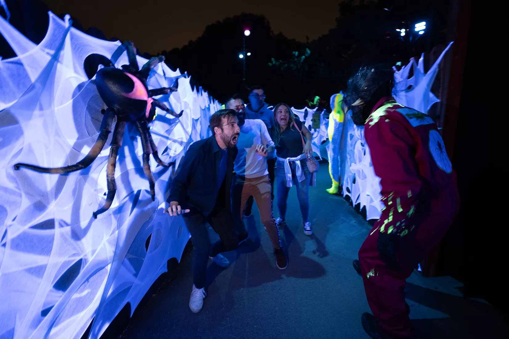 A group of people jumped while scared from one of the actors in costume at Universal Halloween Horror Nights