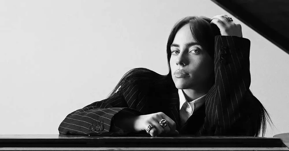 Black and white photograph of Billie Eilish wearing a suit, in a recent interview she shared that she is attracted to women