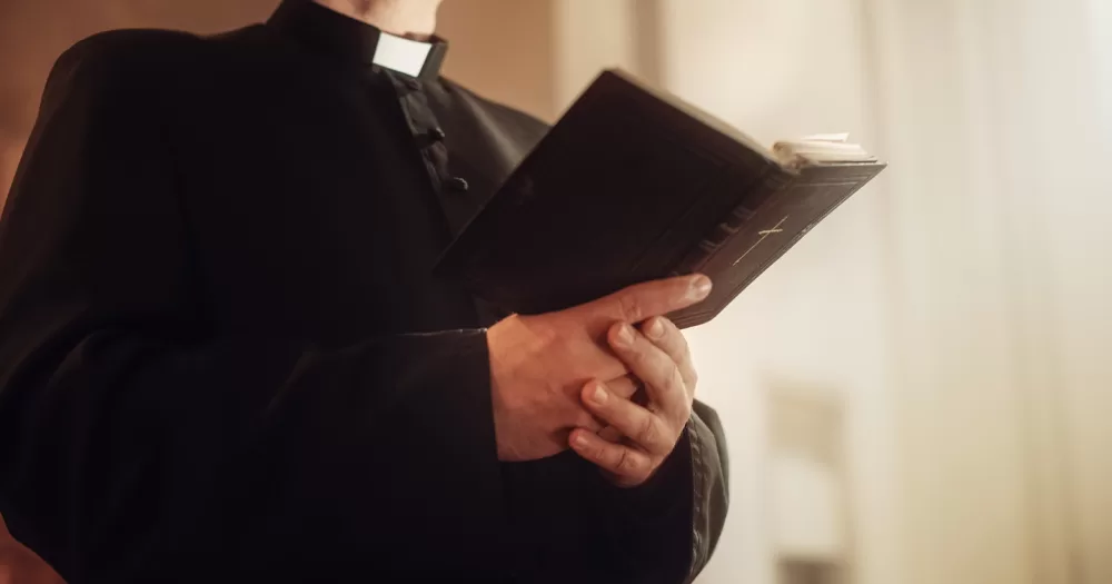 This article is about bishops supporting same-sex marriages fro priests. In the photo, a priest holding a Bible in their hands.