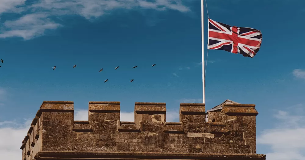 This article is about British colonialism and its legacy of homophobia. In the photo, a UK flag flying on top of a tower.