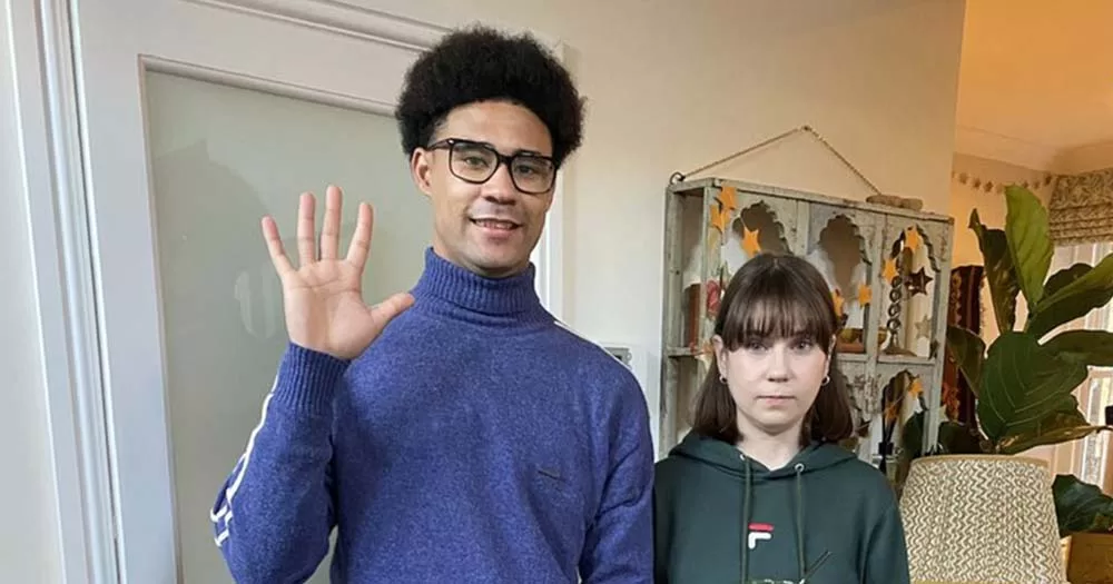 Photograph of Darragh Hand waving and posing next to Heartstopper cast mate